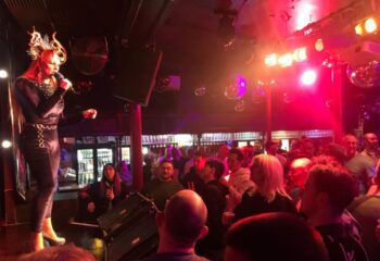 Drag show at Royal Vauxhall Tavern, London. A performer sings to a crowd at this popular gay bar. RVT's known for its best drag shows.