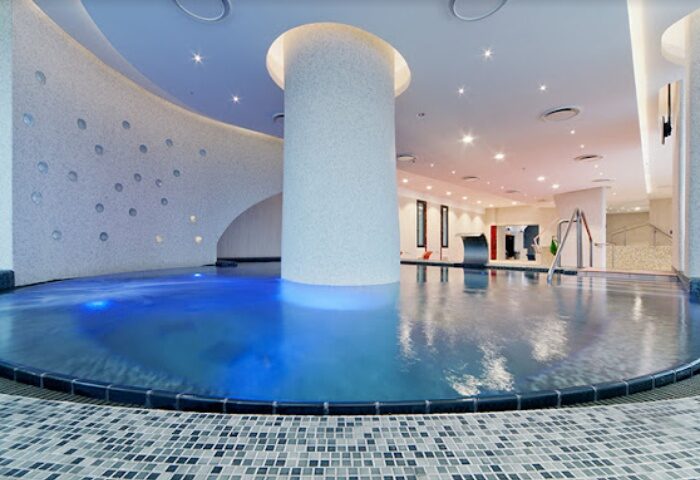 Rudas Thermal Bath, Budapest. Interior view of the pool, with blue water, modern design, and relaxing atmosphere. Gay travel advice.