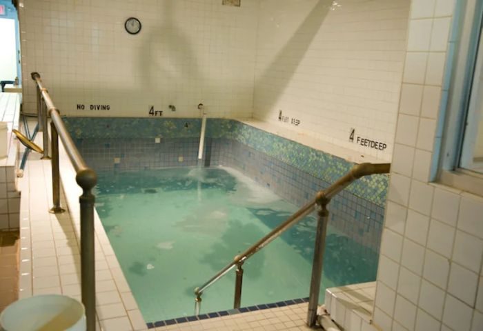 Indoor pool at Russian & Turkish Baths in New York. 4 feet deep, tiled walls, handrails. A gay travel destination for relaxation.