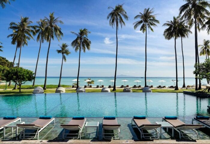 SAii Phi Phi Island Village: Luxury gay honeymoon. Private beach hotel pool with palm trees, lounge chairs, and ocean view. Paradise.