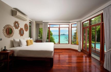 SAii Phi Phi Island Village: Top private pool villa. Bedroom with sea view, wooden floor, bed, and mirrors. Gay travel destination.