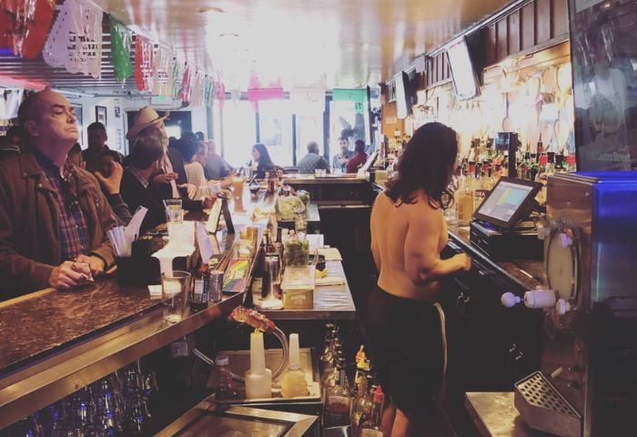 Gay bar in San Francisco. A busy bar scene with patrons and a bartender. A popular destination for gay men's travel in SF.