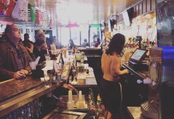 Gay bar in San Francisco. A busy bar scene with patrons and a bartender. A popular destination for gay men's travel in SF.