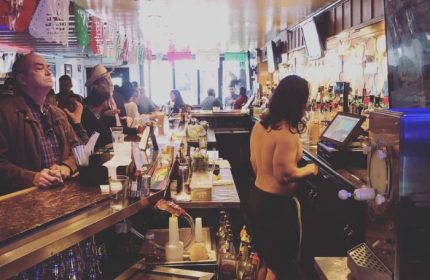 Gay bar in San Francisco. A busy bar scene with patrons and a bartender. A popular destination for gay men's travel in SF.