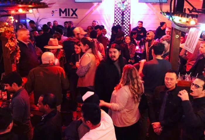 Inside Mix, a busy gay bar in San Francisco. Patrons mingle in the lively atmosphere. Nightlife scene for gay men's travel.