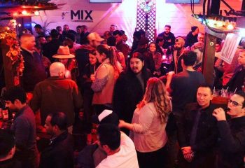 Inside Mix, a busy gay bar in San Francisco. Patrons mingle in the lively atmosphere. Nightlife scene for gay men's travel.