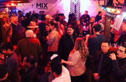 Inside Mix, a busy gay bar in San Francisco. Patrons mingle in the lively atmosphere. Nightlife scene for gay men's travel.