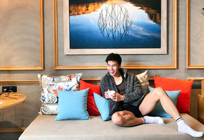 Gay man relaxing at SO/ Sofitel Hua Hin, Thailand. Smiling man with coffee in stylish hotel room. Gay travel at SO Sofitel Hua Hin.