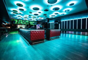 Safari Disco Club, Barcelona's gay club. Interior view of the bar with red tufted leather, blue lighting, and a unique ceiling design.