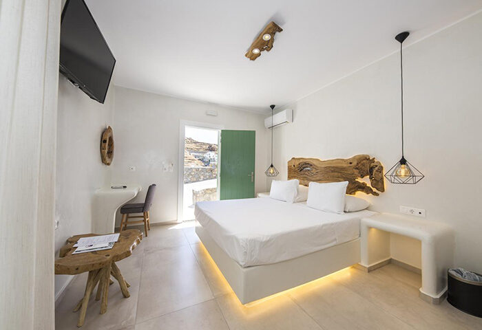 Sahas Suites Mykonos self-catering apartment bedroom. Modern design, white linens, wood accents. Near gayborhood, ideal for gay travel.