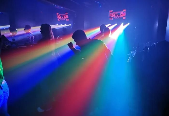 Gay nightlife at Sala Republik Club, Madrid. People dance under rainbow lights in the gay club. Gay travel advice.