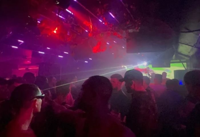 Inside Sala Republik Club, a gay club in Madrid. People dancing, laser lights, and a vibrant atmosphere. Gay nightlife travel.