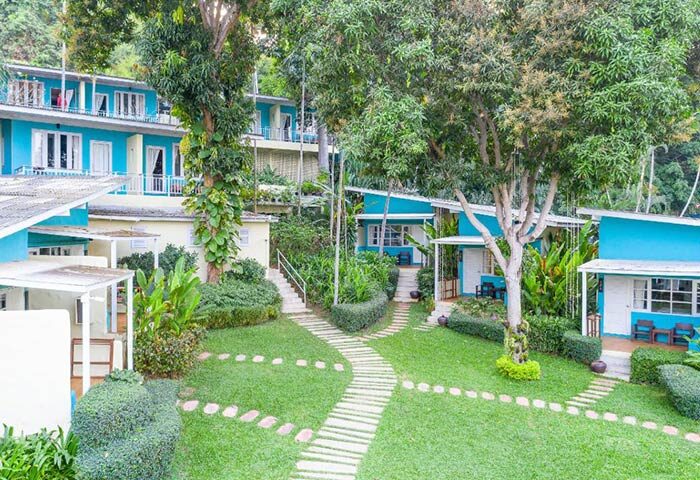 Samed Club Resort, Koh Samet. Popular beachfront gay hotel with blue and white bungalows, lush greenery, and stone pathways. Instagram spot.