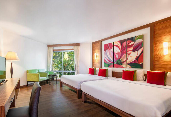 Samed Pavilion Resort room. Best gay hotel in Koh Samet for gay groups near nightlife. Twin beds, sofa, and floral art. Thailand travel.