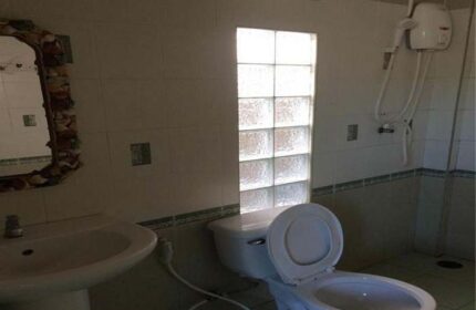 Samet Inn, Gay Koh Samet: Bathroom with toilet, sink, shower, and glass block window. Budget-friendly travel option for gay men visiting Thailand.