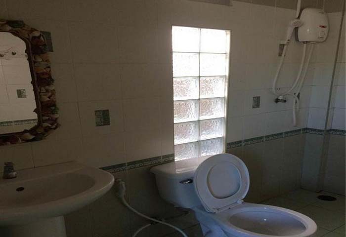 Samet Inn, Gay Koh Samet: Bathroom with toilet, sink, shower, and glass block window. Budget-friendly travel option for gay men visiting Thailand.