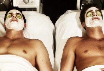 Two gay men receiving face masks and cucumber eye treatment at Santorini Zen Spa. Gay travel advice for relaxing spa day in Santorini, Greece.