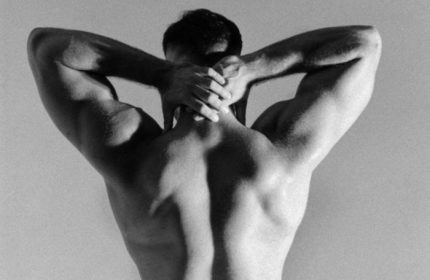 Sasha Bloom by Sasha massage experience: Muscular gay man's back in black and white. Ideal for gay travel, health, and wellness content.