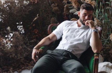 Sasha Bloom by Sasha: Handsome gay man relaxing in a chair. Massage therapist for gay men travel advice. Portrait.