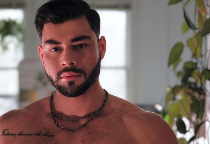 Sasha Bloom by Sasha: Portrait of a handsome, muscular gay man with a beard and chest tattoo. Perfect for gay travel inspiration.