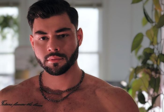Sasha Bloom by Sasha: Portrait of a handsome, muscular gay man with a beard and chest tattoo. Perfect for gay travel inspiration.