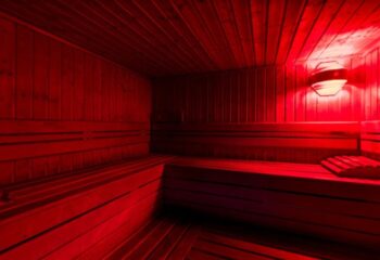 Sauna Apolo Lisbon interior. Red light illuminates wooden benches & walls. Gay travel in Lisbon, Portugal. Relaxing spa experience for gay men.