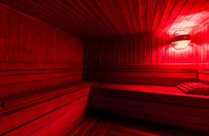 Sauna Apolo Lisbon interior. Red light illuminates wooden benches & walls. Gay travel in Lisbon, Portugal. Relaxing spa experience for gay men.