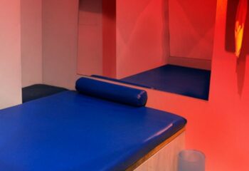 Inside Bruc Gay Sauna in Barcelona: Blue padded bed, bolster, and mirrored room. A popular gay travel destination for relaxation.
