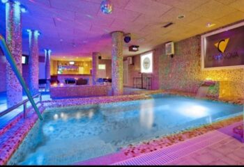 Casanova Gay Sauna in Barcelona. Interior view of the sauna with pool, bar, and mosaic tile decor. A popular gay travel destination.