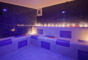 Casanova gay sauna in Barcelona steam room. Relaxing gay travel destination with blue tile, candles, and rose petals. Gay sauna in Spain.