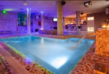 Sauna Casanova Barcelona: Interior view of the gay sauna with a pool, bar, and ambient lighting. A relaxing gay travel destination.