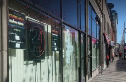 Montreal gay sauna in Centre-Ville. The glass front of the building has a sign that says 24 hrs. Cruising spot for gay men in Montreal.