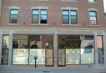 Facade of Sauna Centre-Ville, a gay cruising location in Montreal. Brick building with large windows and signage. Travel advice.
