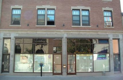 Facade of Sauna Centre-Ville, a gay cruising location in Montreal. Brick building with large windows and signage. Travel advice.