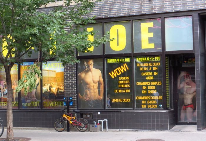 Sauna G.I. Joe in Montreal: Exterior view. A popular gay sauna with signage and images of muscular men in the windows. Bike parked outside.