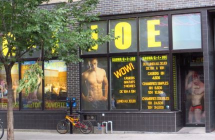 Sauna G.I. Joe in Montreal: Exterior view. A popular gay sauna with signage and images of muscular men in the windows. Bike parked outside.