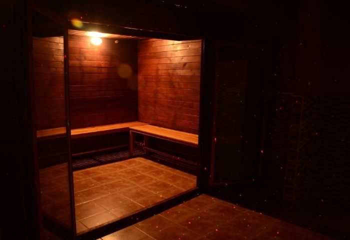 Interior of Sauna Lavapies, a gay sauna in Madrid. Wooden benches and walls, tiled floor, and dim lighting create a relaxing atmosphere.