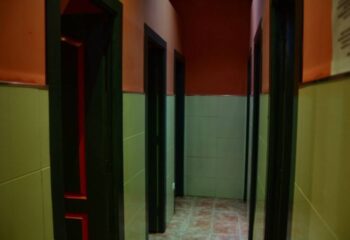Hallway view inside Sauna Lavapies, a gay sauna in Madrid. Doors and tiled walls lead to different areas in the sauna.