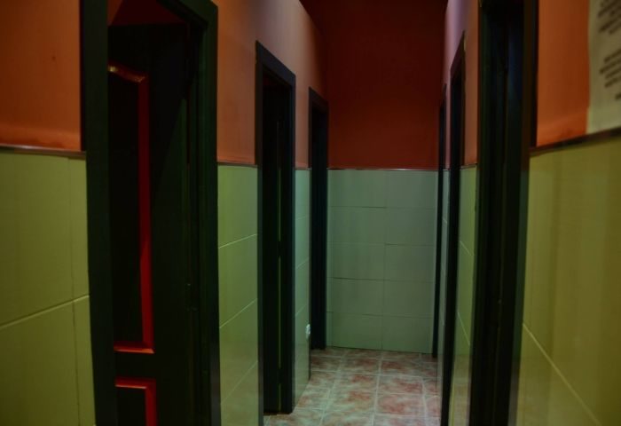 Hallway view inside Sauna Lavapies, a gay sauna in Madrid. Doors and tiled walls lead to different areas in the sauna.