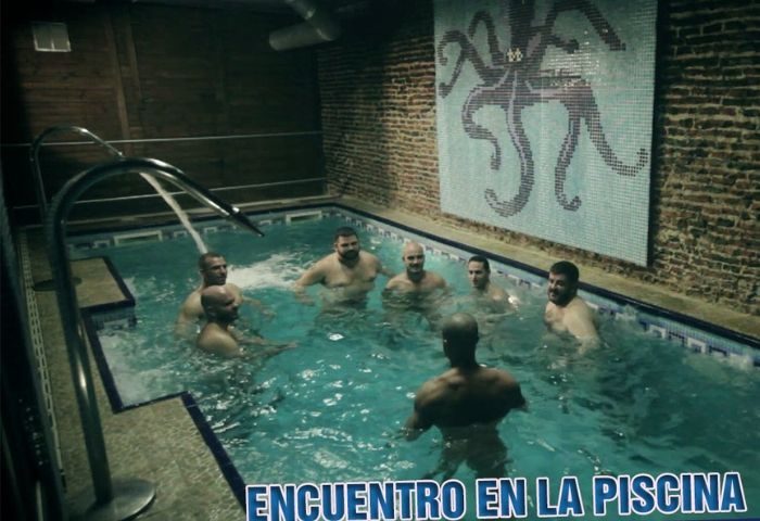 Gay sauna in Madrid: Men relaxing in a pool at Sauna Octopus. Mosaic octopus art on the wall. Gay travel advice.