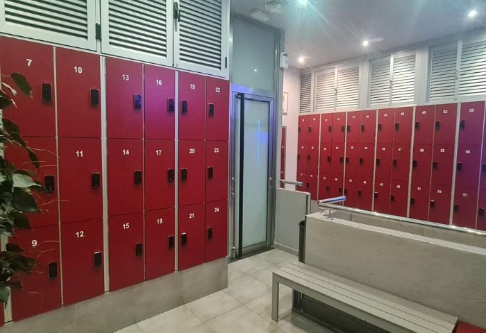 Gran Canaria gay sauna lockers. Red lockers with numbers, bench, and glass door. A safe place for gay men to relax and enjoy their travel.