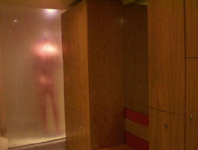 Saunabar London Portsea: Blurred figure behind glass in gay sauna showers. Lockers visible. Gay travel advice for London's gay sauna scene.