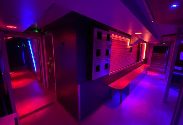 Saunawerk Frankfurt interior. Gay sauna with blue and red neon lights, lockers, and benches. A modern, industrial design for gay men's travel.