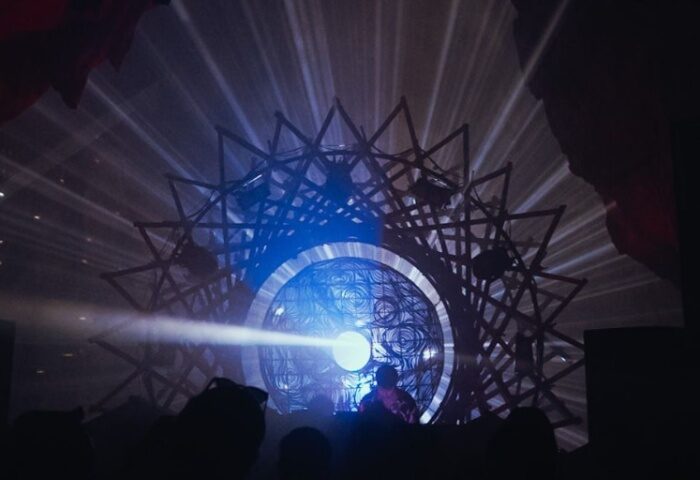 Savage Hanoi gay party. DJ silhouette on stage with geometric light display. Hanoi nightlife, gay travel advice.