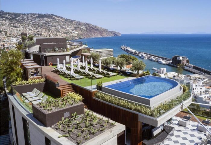 Savoy Palace Madeira Hotel rooftop pool and sun loungers with ocean view. Gay travel luxury resort in Funchal, Madeira, Portugal.