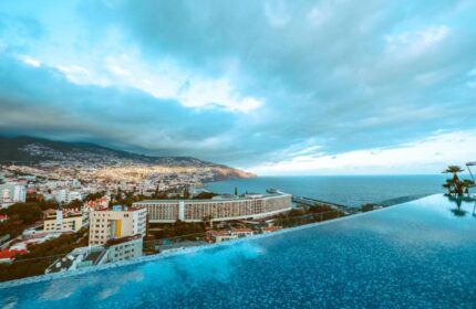 Savoy Palace Madeira rooftop pool view. Ocean and city panorama from luxury hotel. Gay travel destination in Funchal, Portugal.