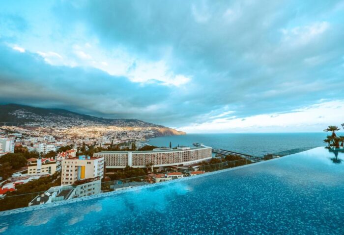 Savoy Palace Madeira rooftop pool view. Ocean and city panorama from luxury hotel. Gay travel destination in Funchal, Portugal.