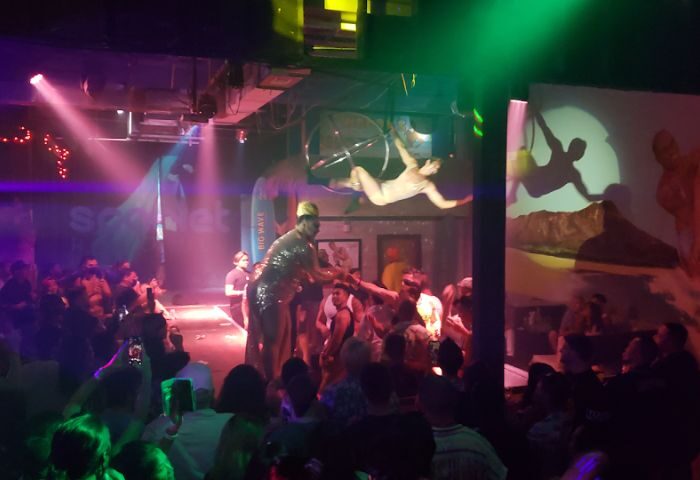 Scarlet Honolulu gay bar scene. Drag queen performing for a crowd, with aerial acrobatics. Gay nightlife in Honolulu, Hawaii.