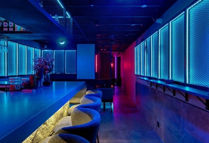 Madrid's Secret Room Bar interior. Gay bar with neon lights, bar stools, and a modern design. Nightlife destination for gay travelers.