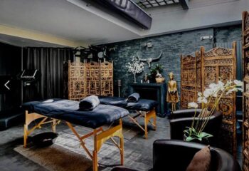 Sensation Spa interior. Massage tables, dark walls, and ornate screens create a relaxing atmosphere. Gay men's travel advice.
